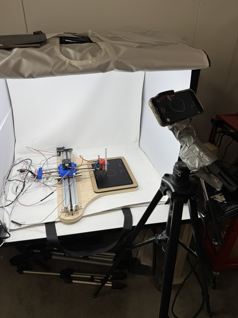Drawing machine test setup on a table with camera and lighting